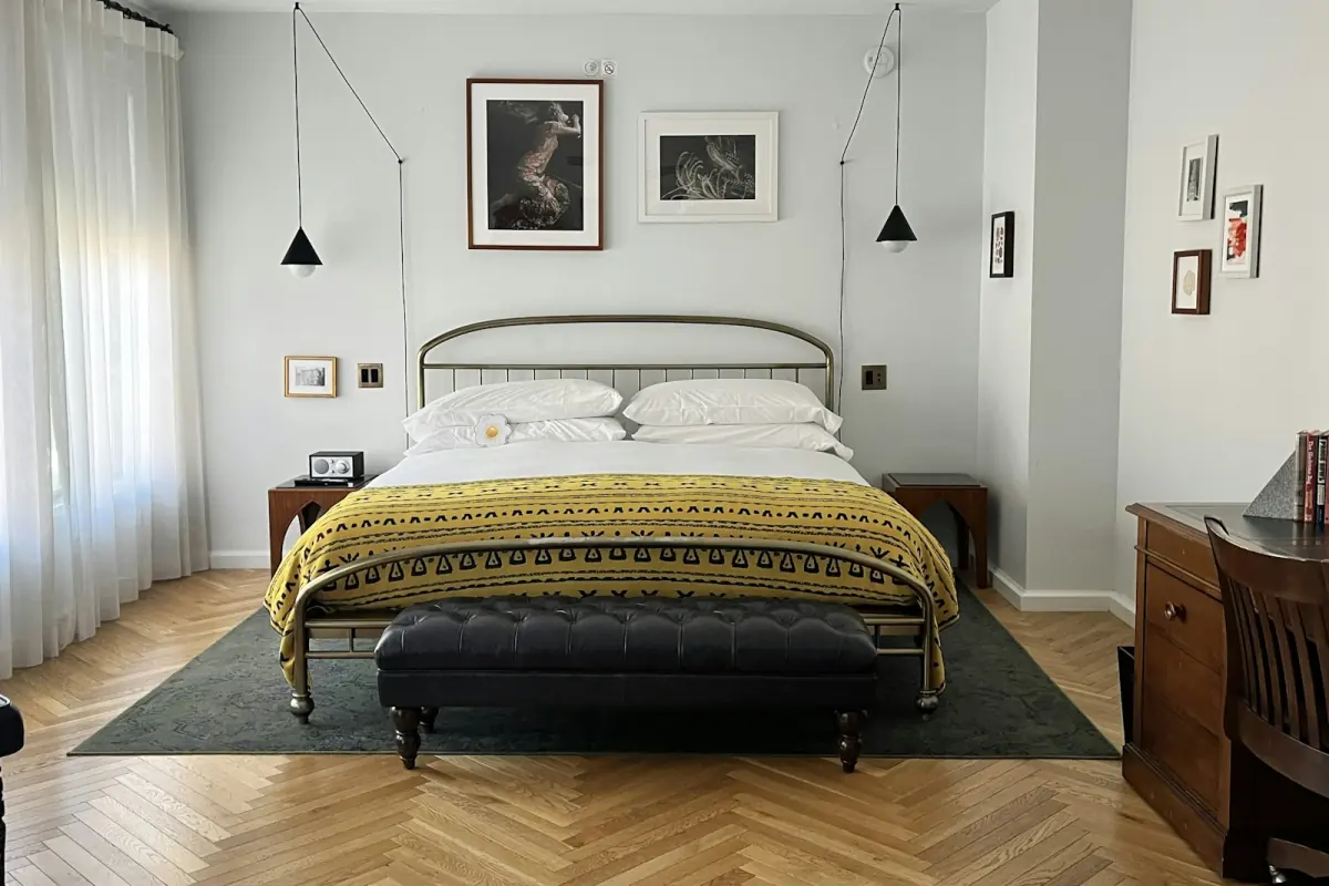 Boutique hotel room with an iron bed, artwork and warm light